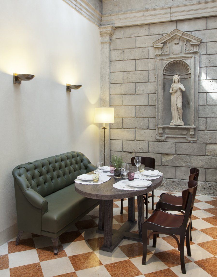 Una stanza con tavolo e sedie e una statua sul muro