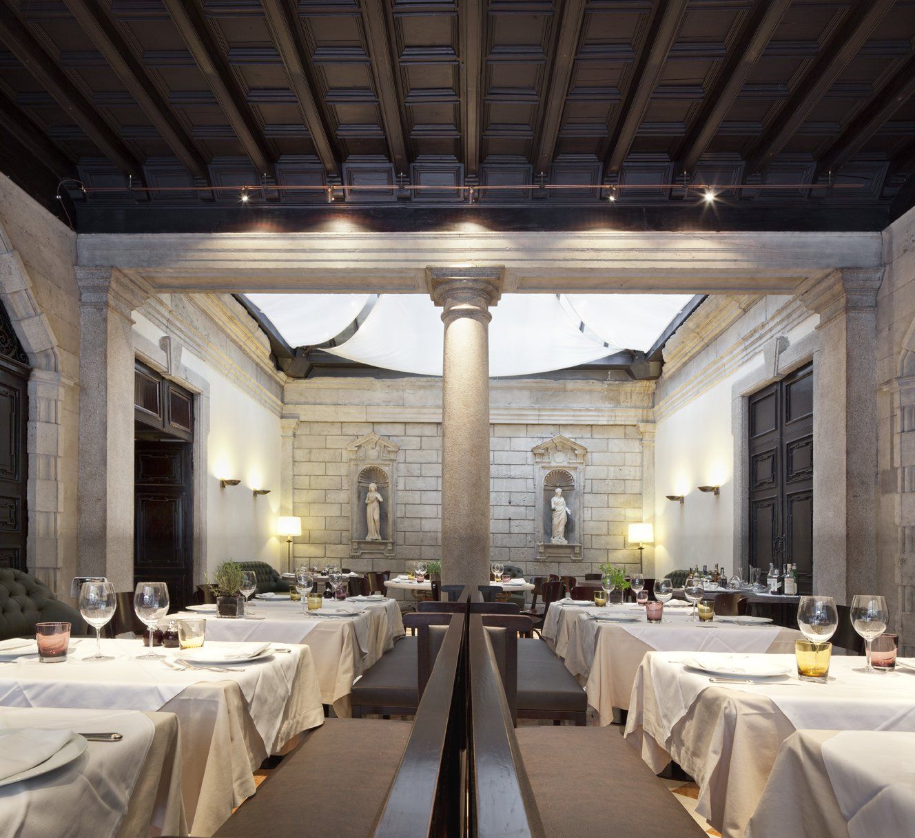 Una sala da pranzo con tavoli e sedie e una statua alla parete