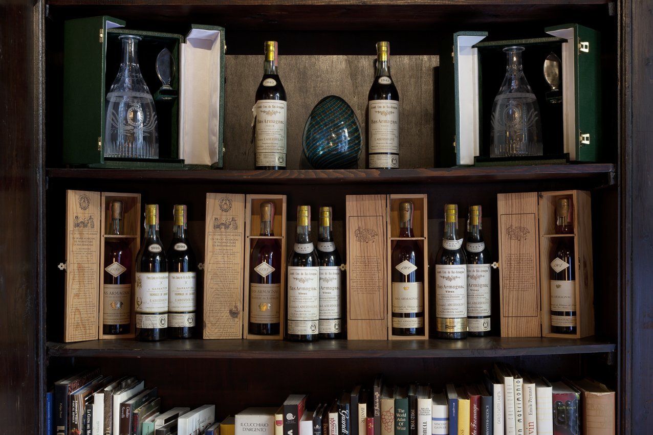 Una libreria piena di bottiglie di vino e libri