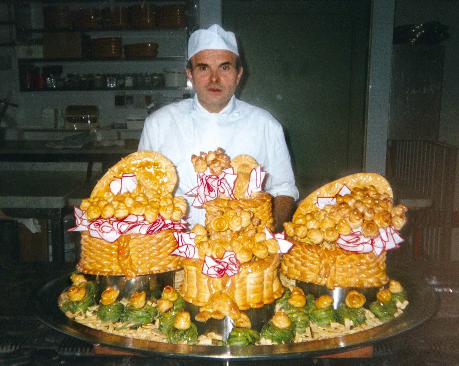 Uno chef sta davanti a una grande esposizione di cibo