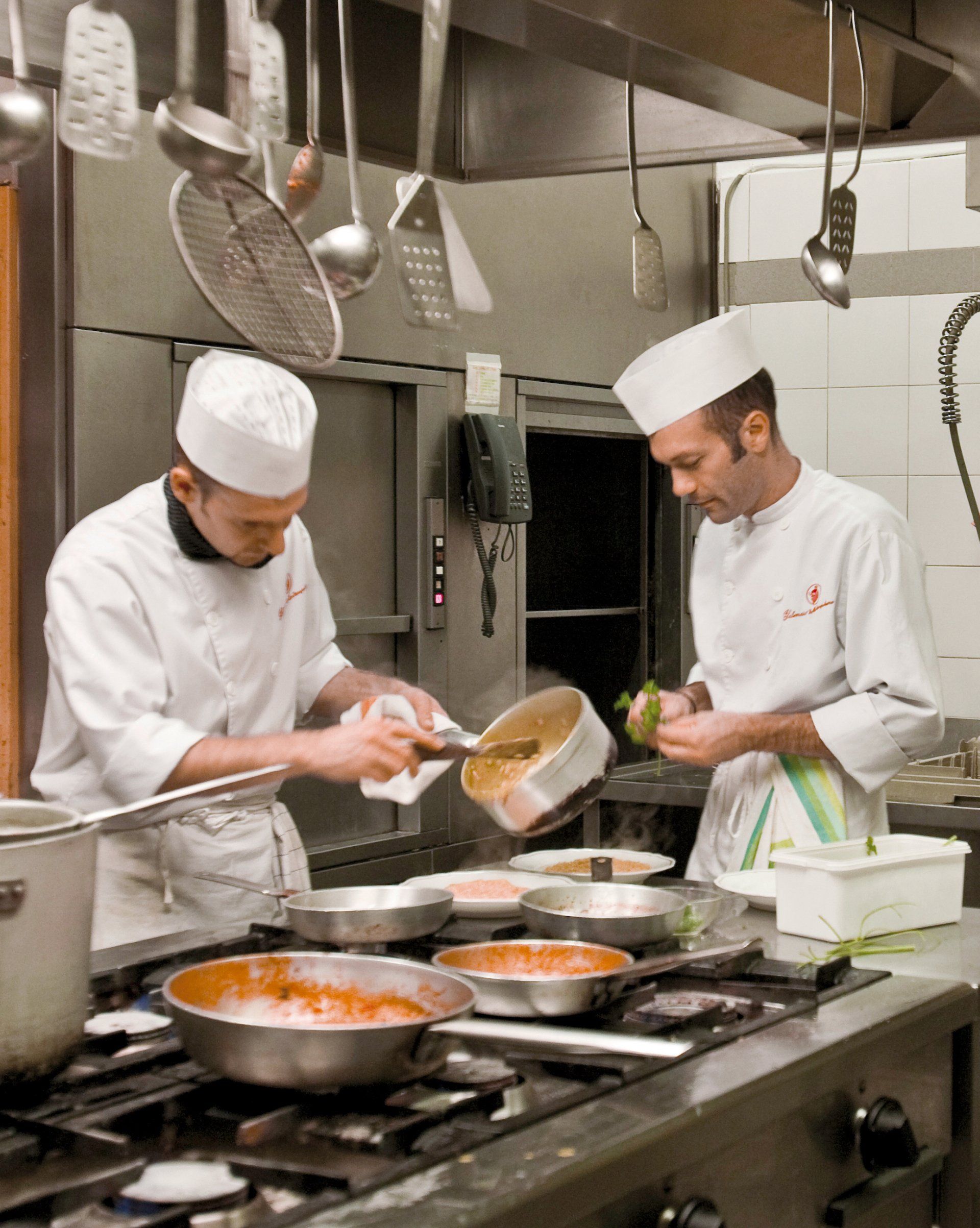 Due chef stanno preparando il cibo in una cucina commerciale