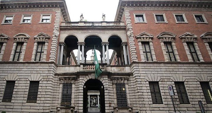 Un grande edificio di mattoni con una bandiera verde davanti