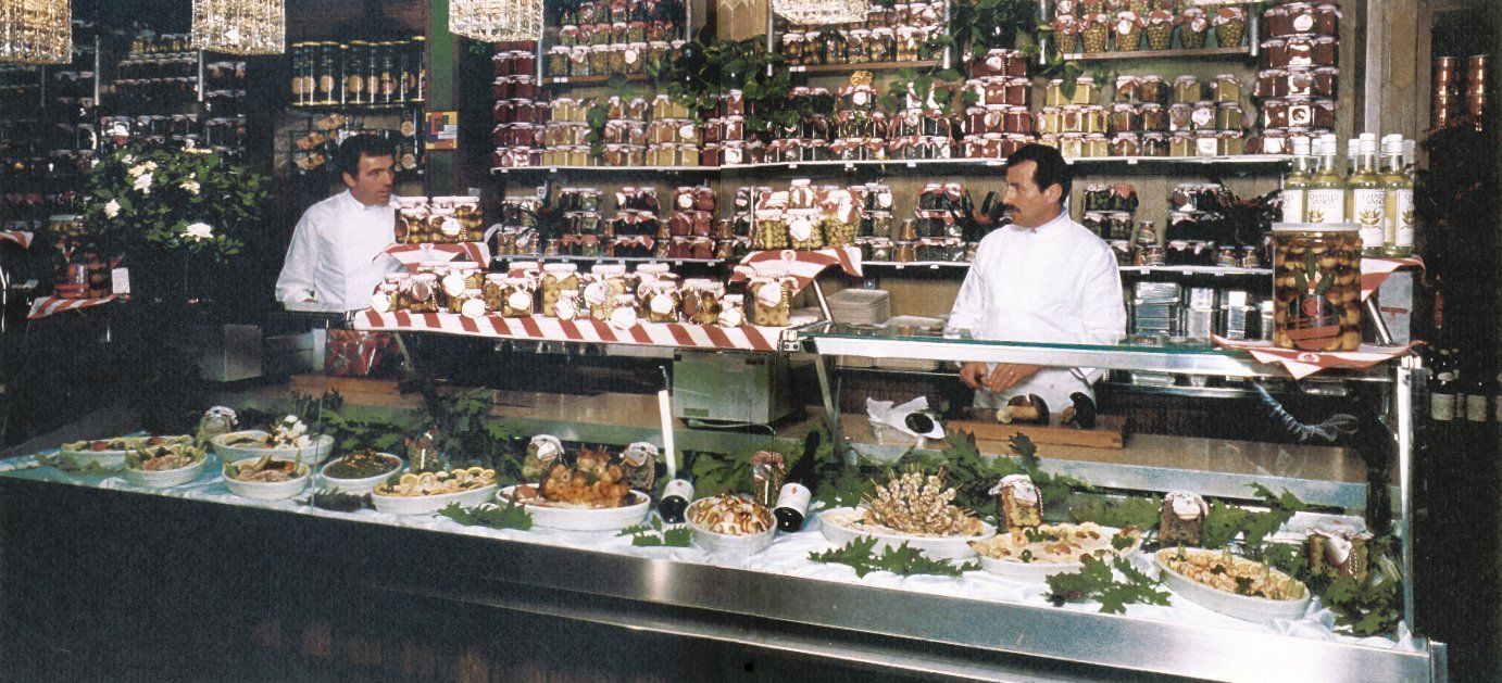 Due uomini in piedi dietro il bancone di un negozio di alimentari