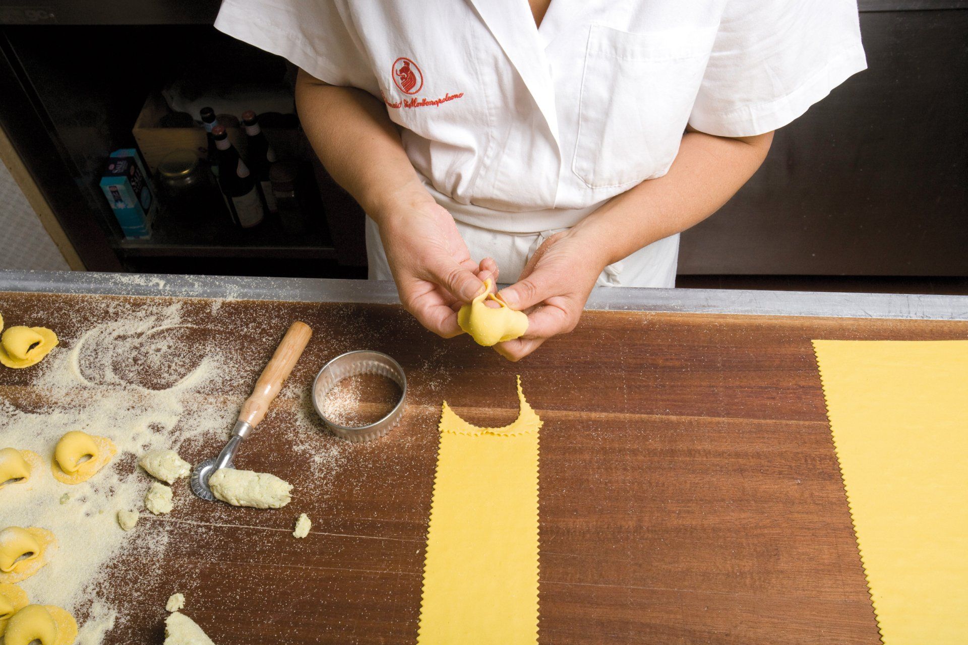 Una persona sta tagliando un pezzo di pasta su un tavolo
