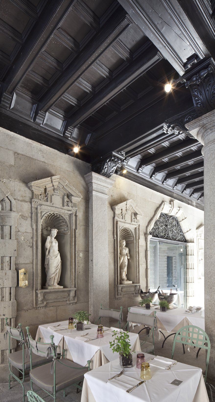 Un ristorante con tavoli e sedie e una statua sul muro.