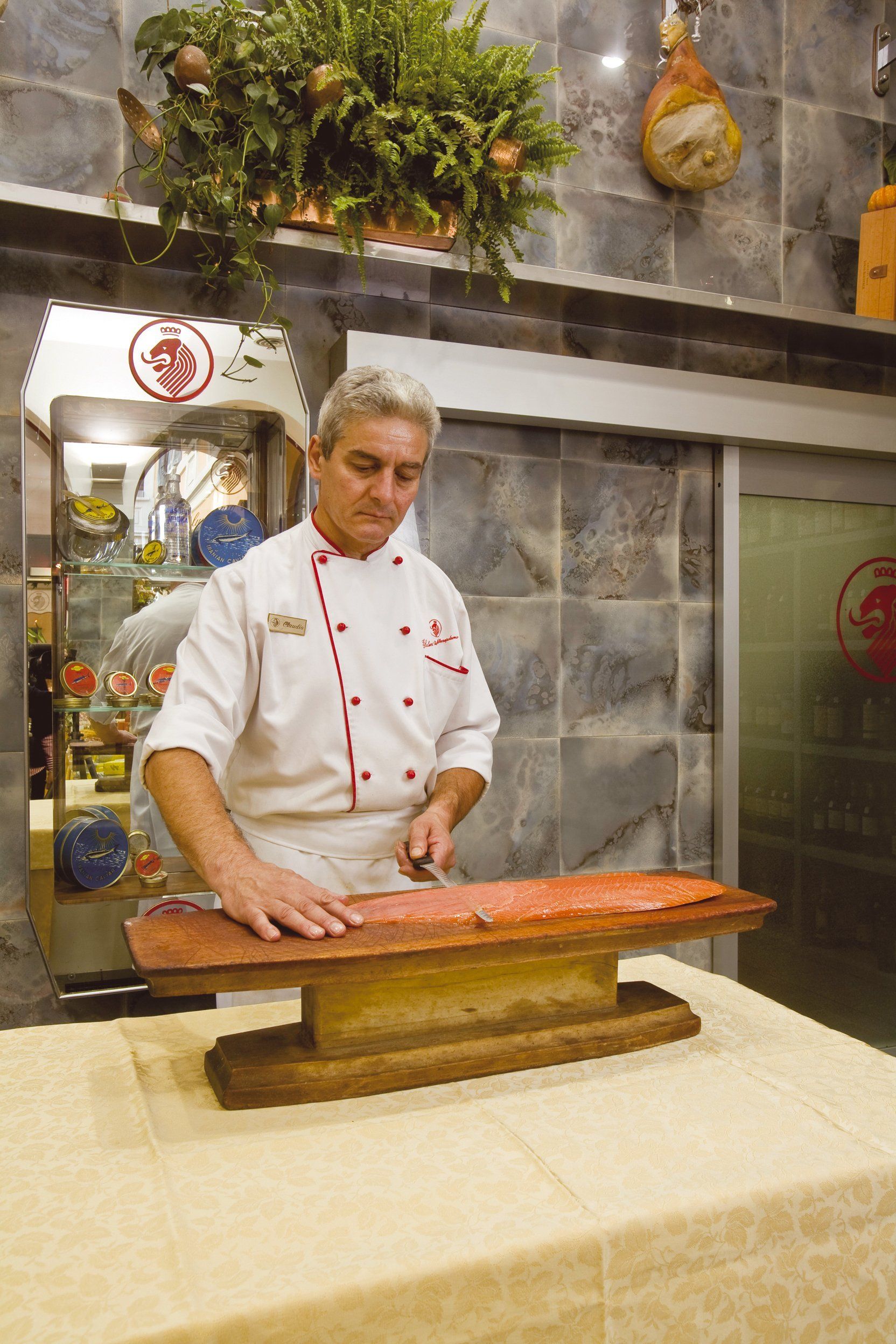 Uno chef taglia un pezzo di carne su un tagliere di legno
