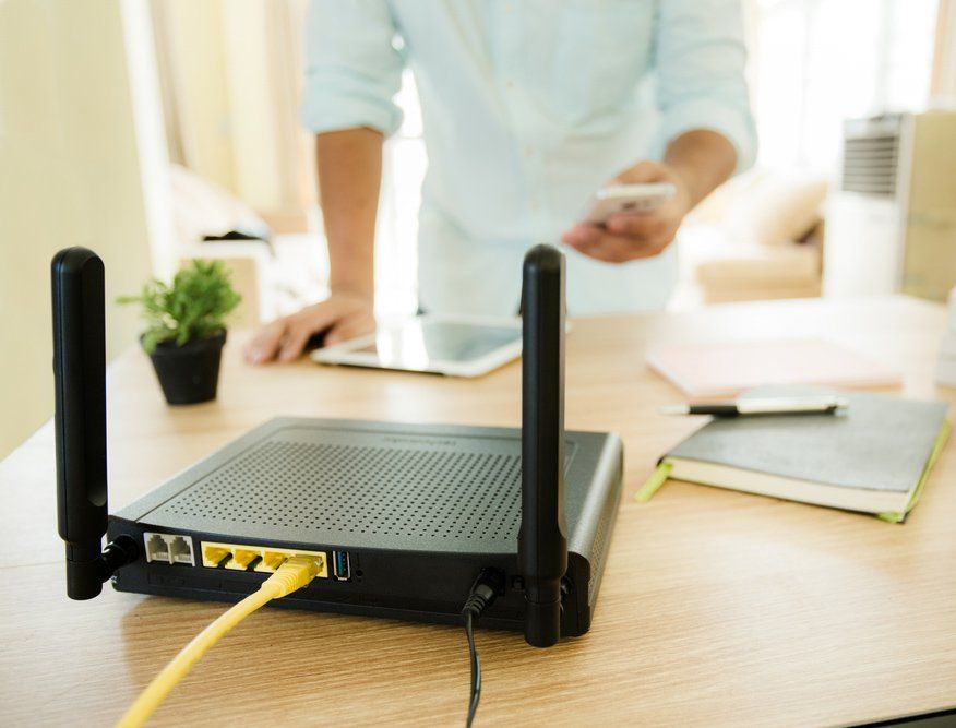 Wireless Router and Man using Smartphone — Frontier Connect in Newtown, QLD