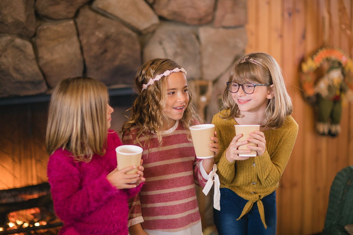 A group of people are picking apples from a tree in an orchard.