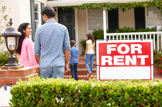 family entering home with red for rent sign