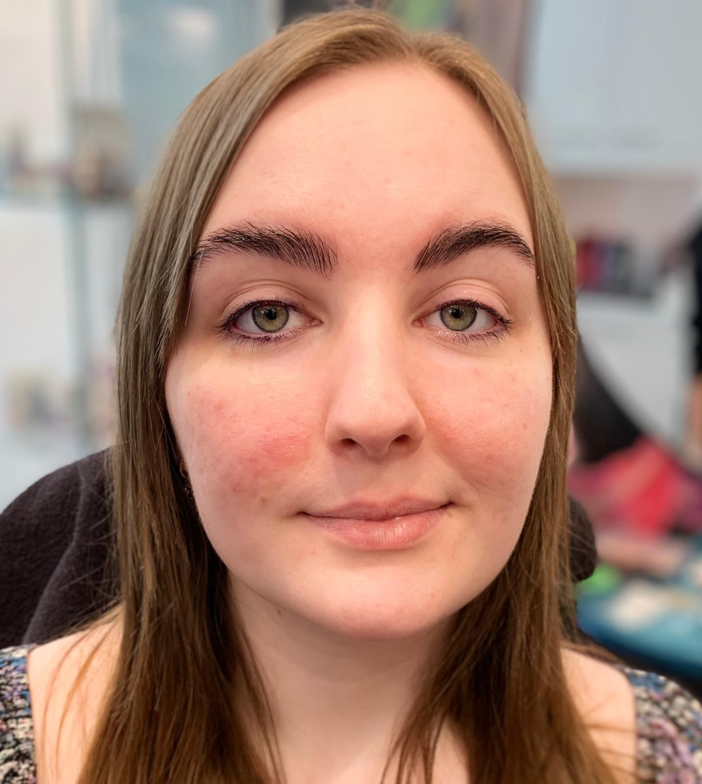 Eine Nahaufnahme des Gesichts einer Frau vor unscharfem Hintergrund.