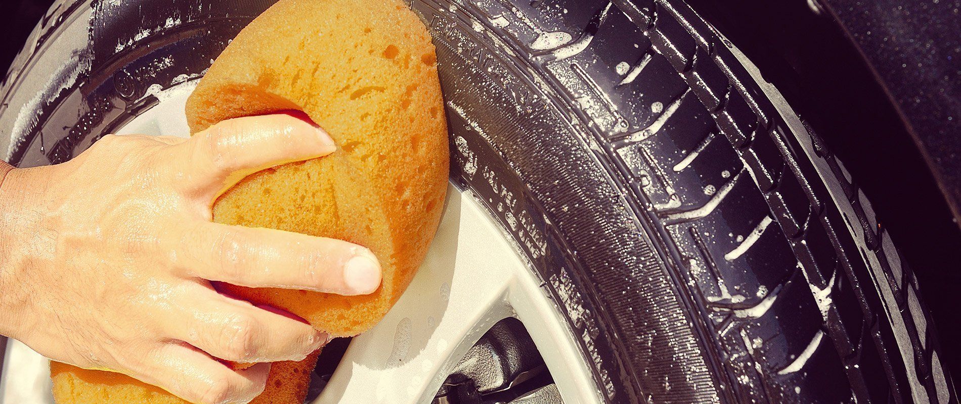 worker cleaning car tire
