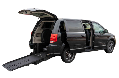 A black van with a ramp attached to the back of it.