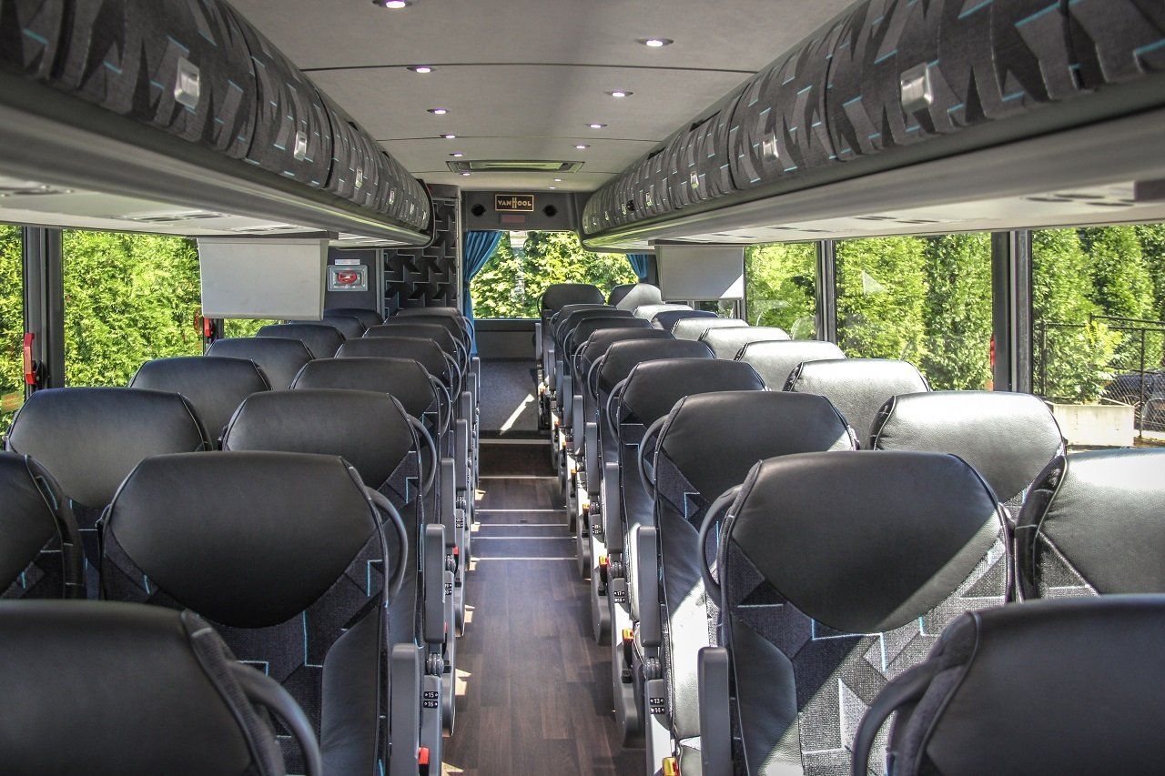 The inside of a bus with a lot of seats and trees in the background.