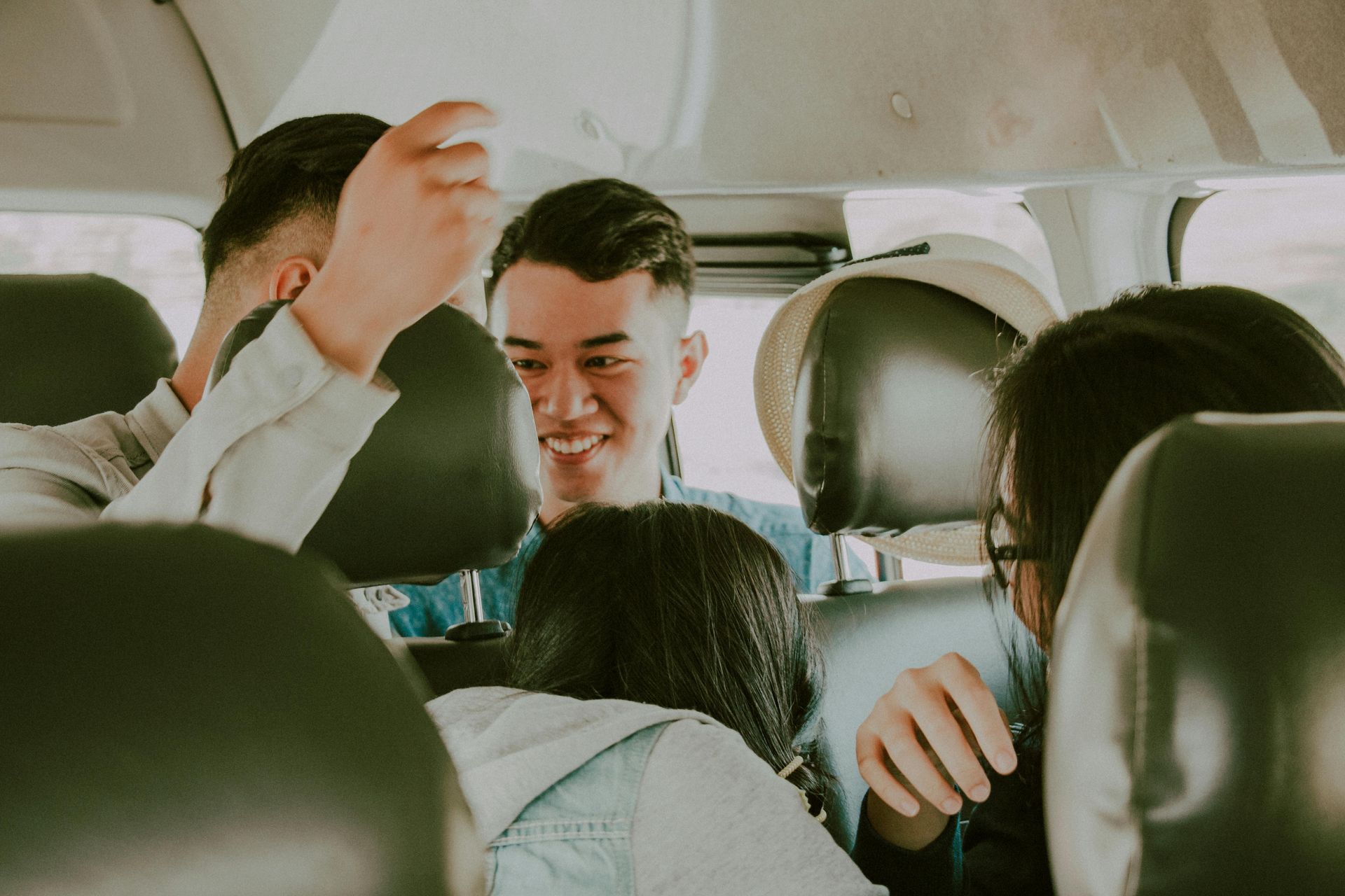 A group of people are sitting in the back seat of a car.