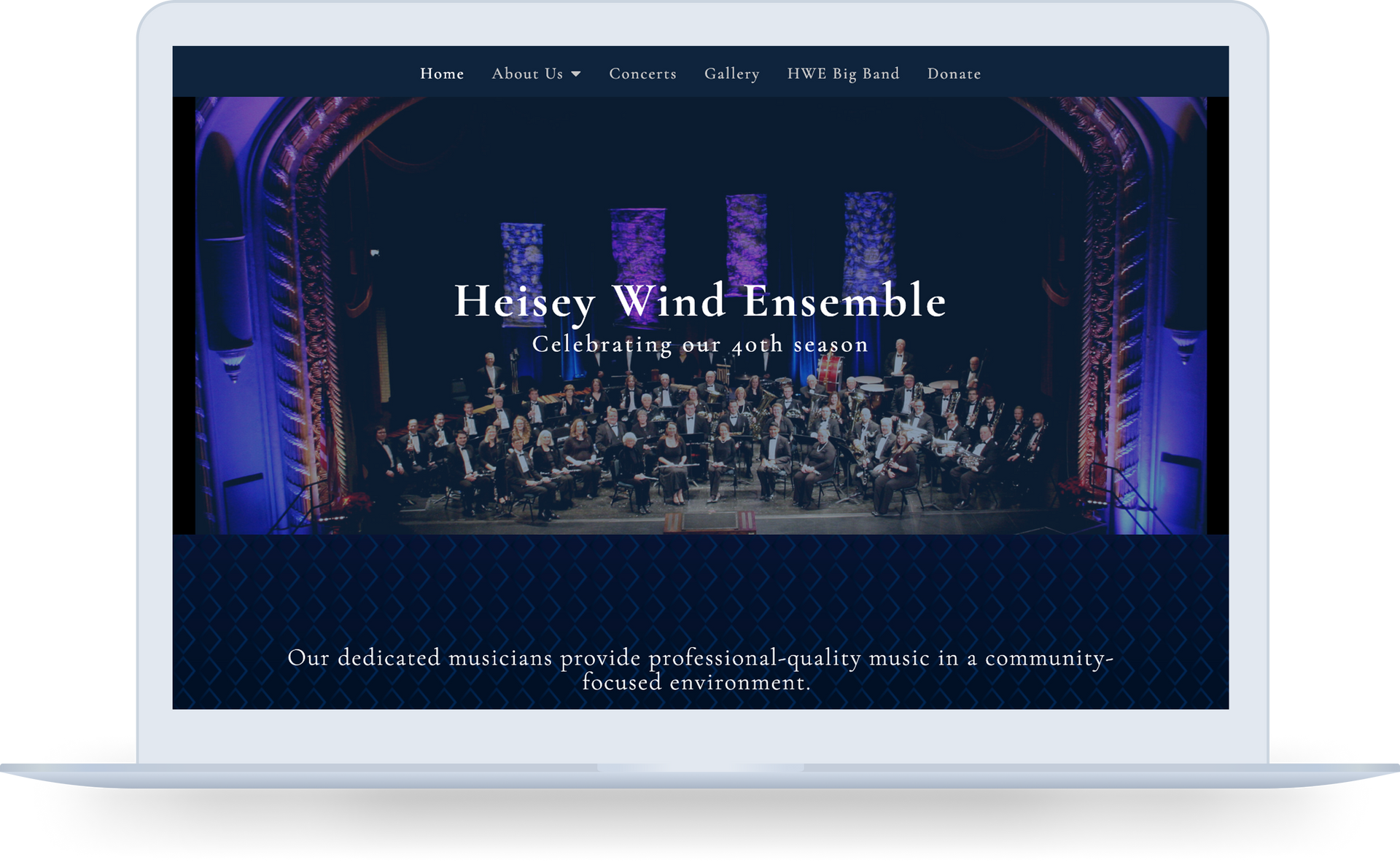 A laptop computer is open to a website for the hessy wind ensemble.