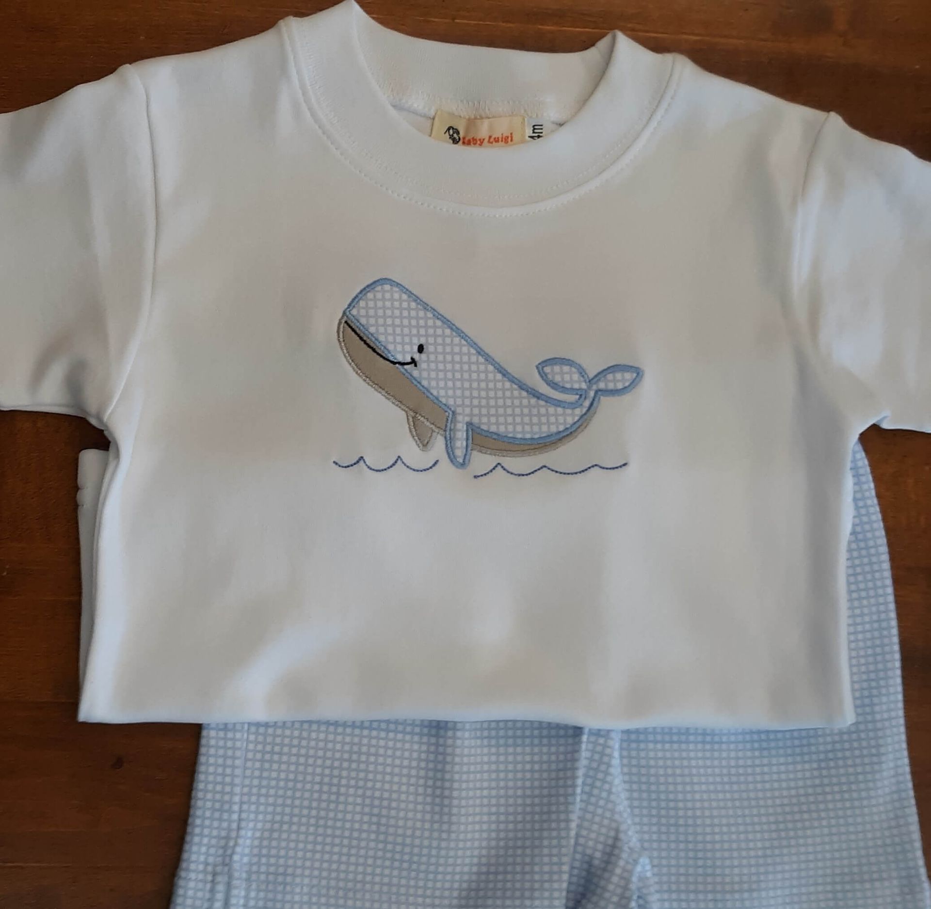 A white shirt with a whale embroidered on it