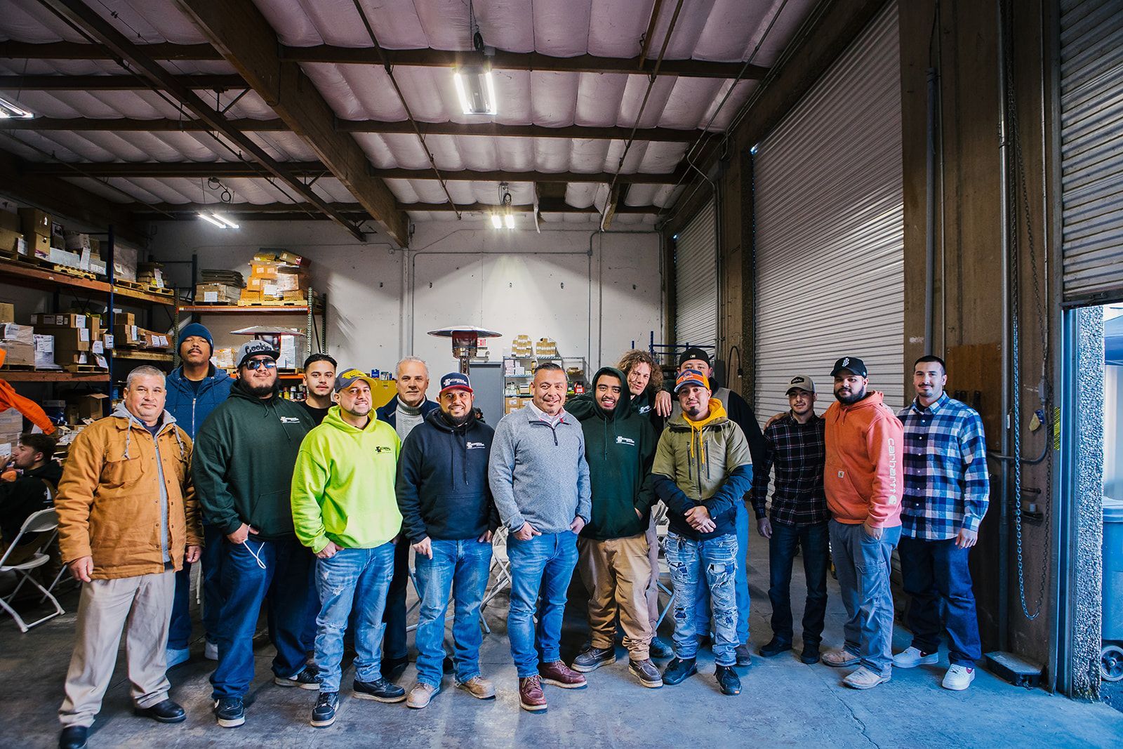 a group of men are posing for a picture in a warehouse .