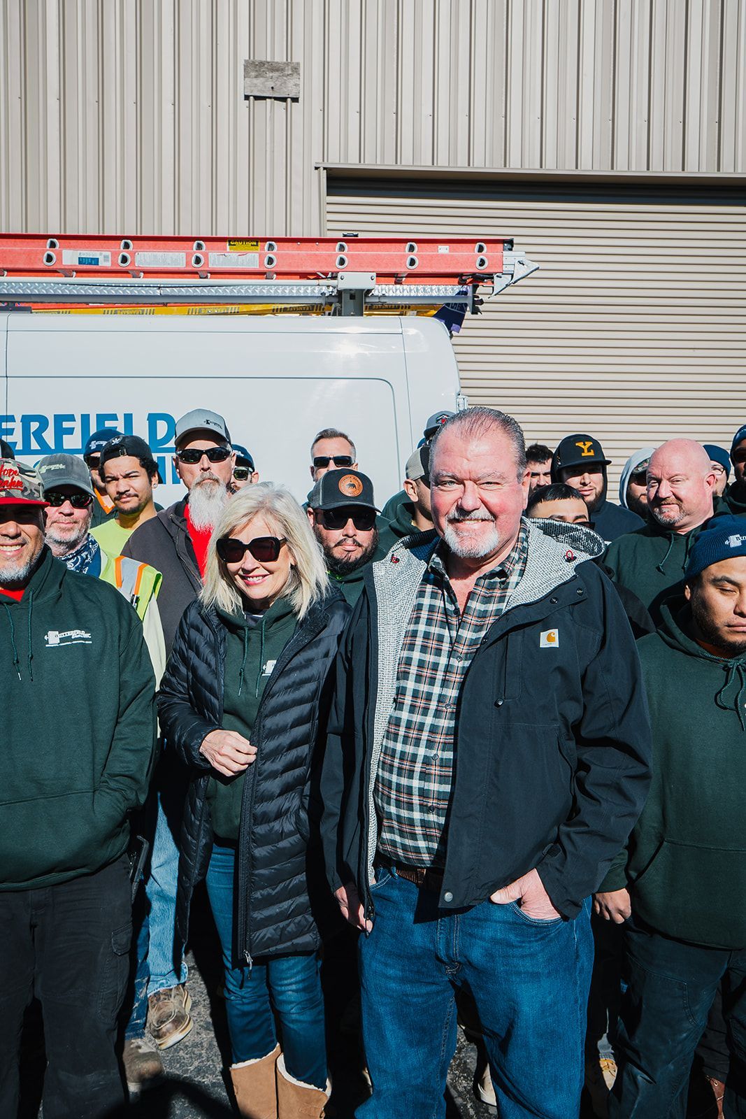 a group of men are posing for a picture in a warehouse .