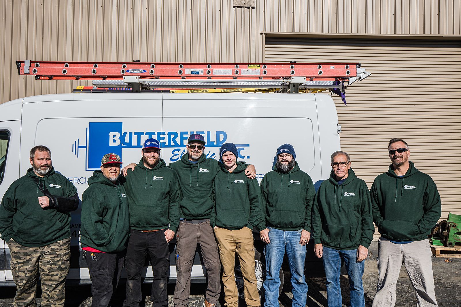 a group of men are posing for a picture in front of a van .