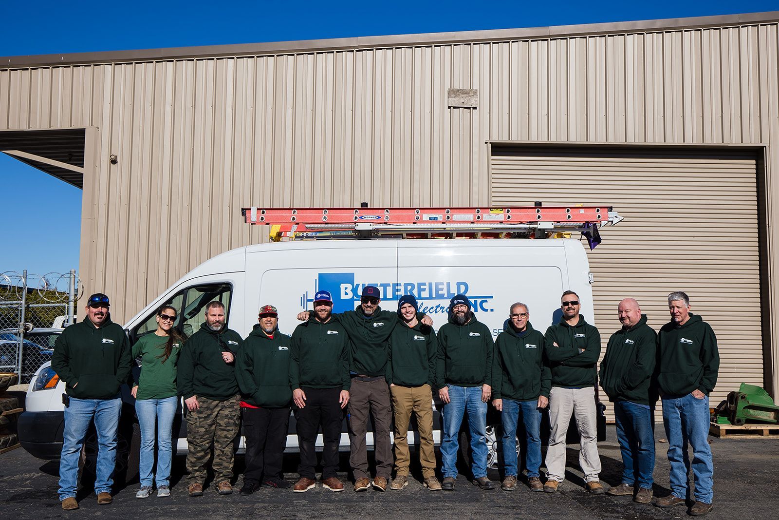 a group of people are posing for a picture in front of a van .