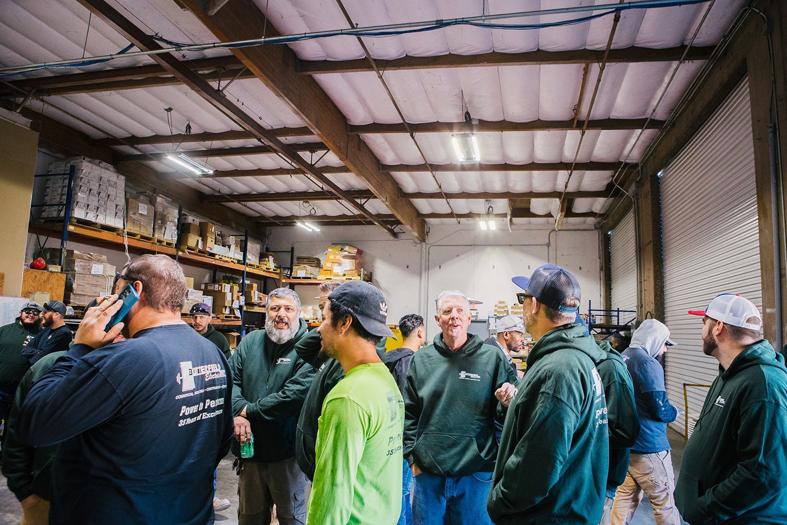 a group of men are standing in a warehouse talking to each other .