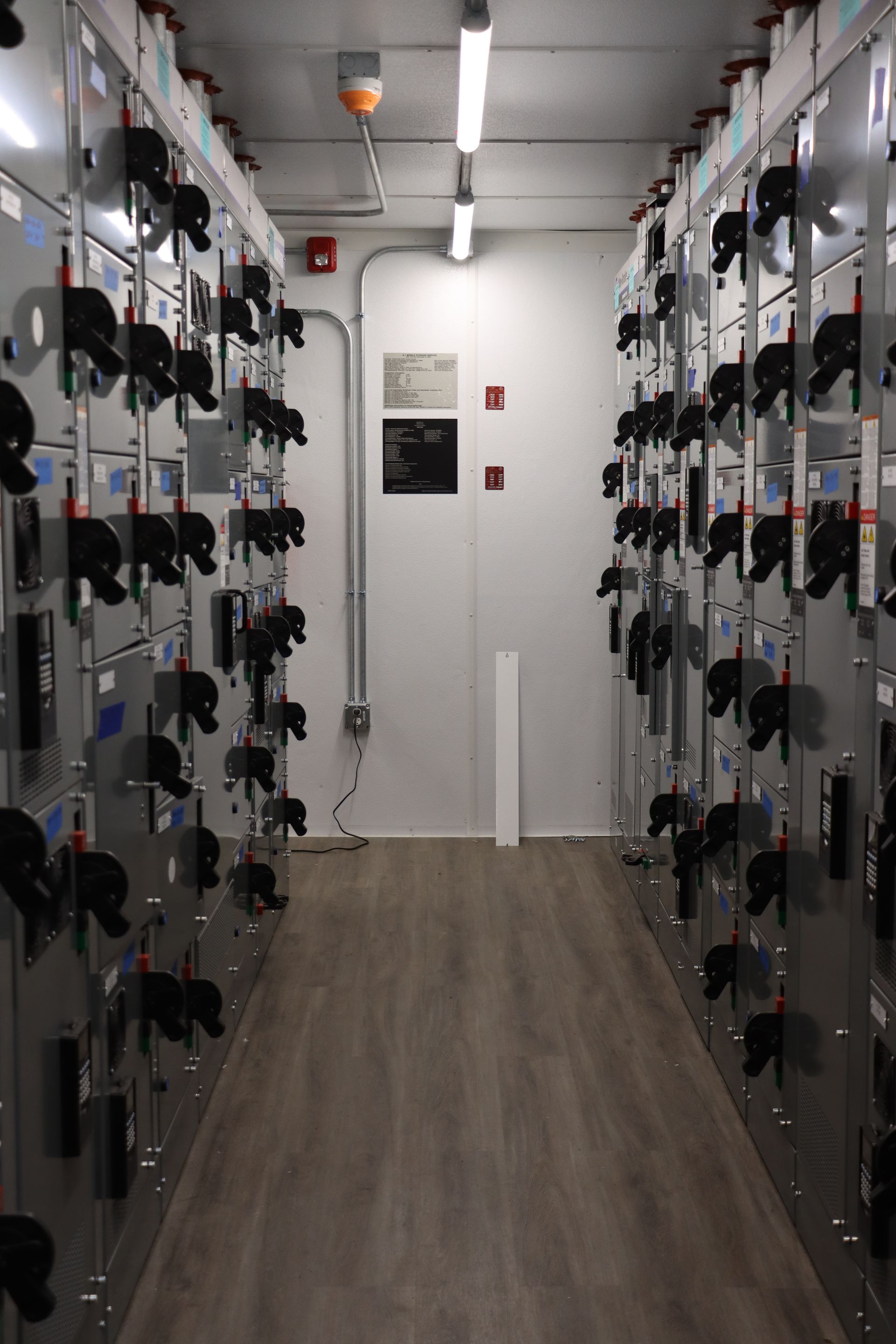a hallway filled with lots of electrical boxes and switches .