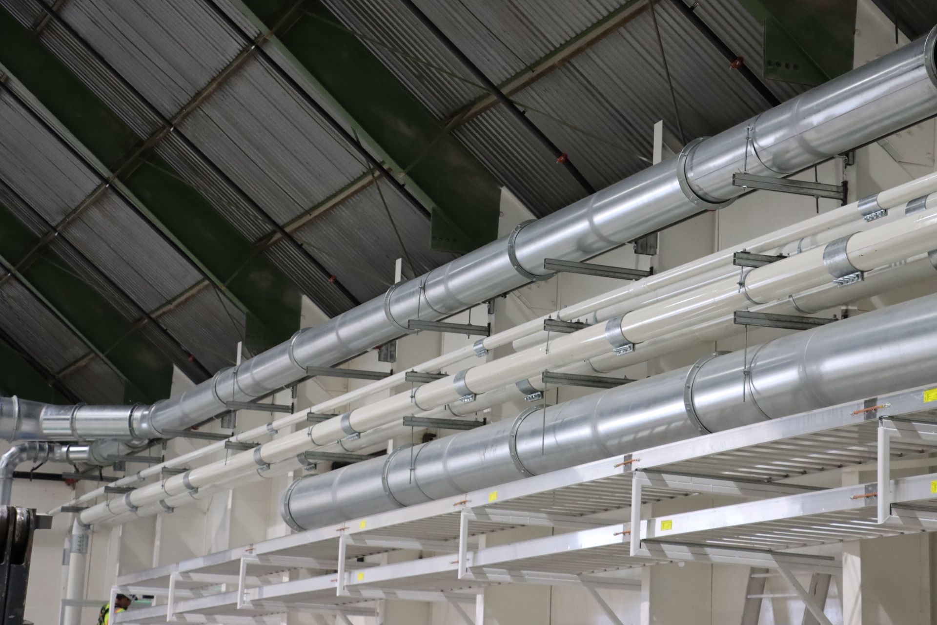 a bunch of pipes are hanging from the ceiling of a building .