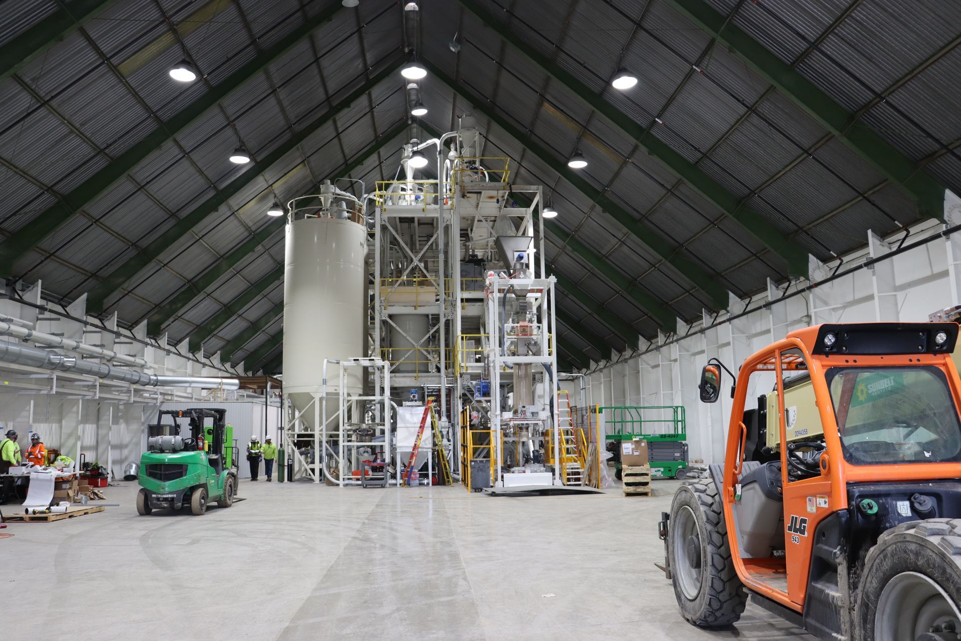 a forklift is parked in the middle of a large warehouse .