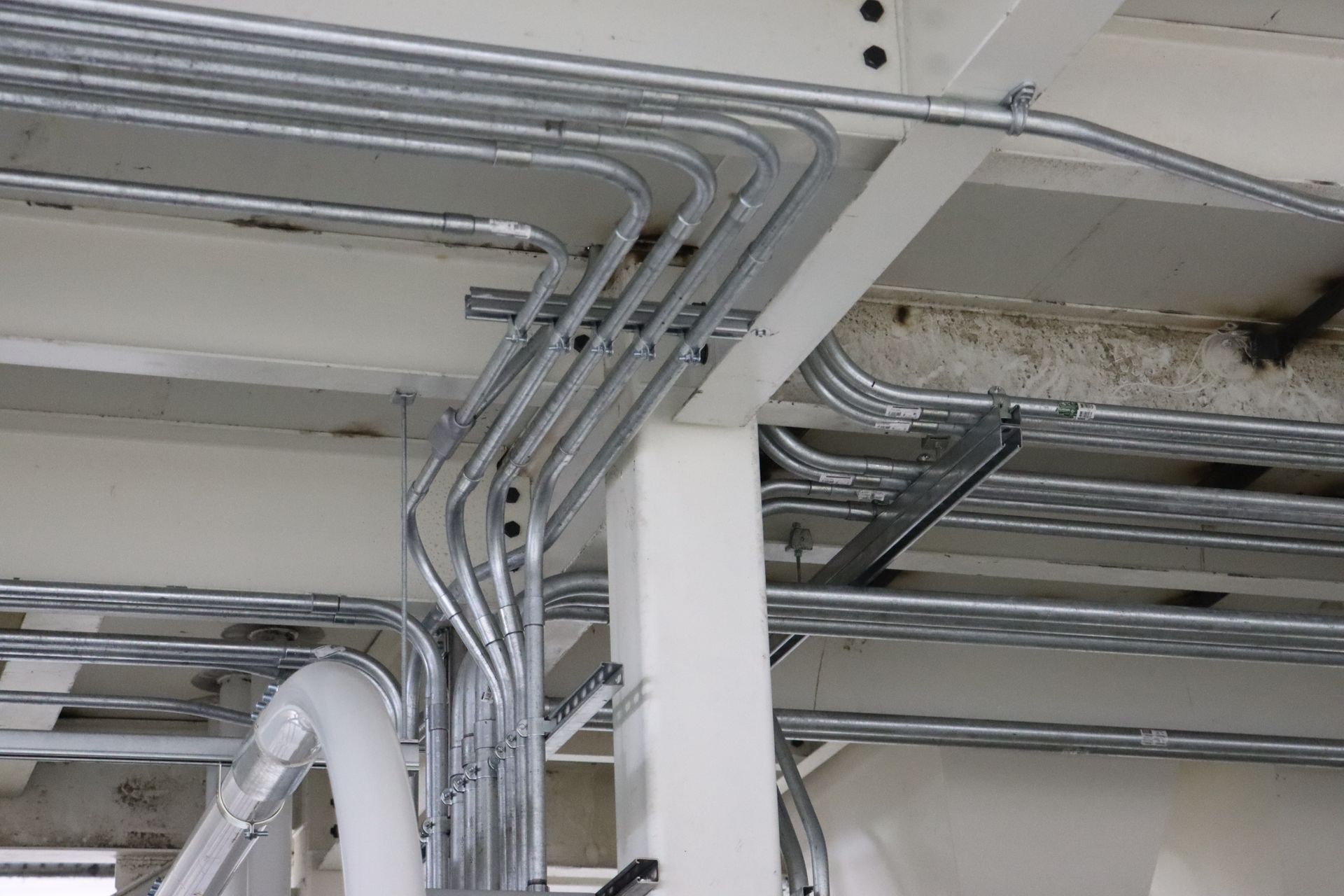 a bunch of pipes are hanging from the ceiling of a building