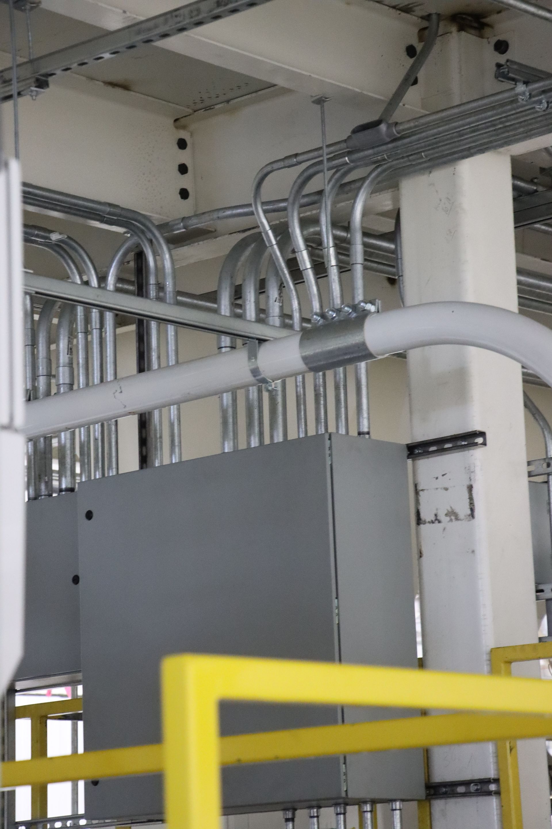 a bunch of pipes are hanging from the ceiling of a building .