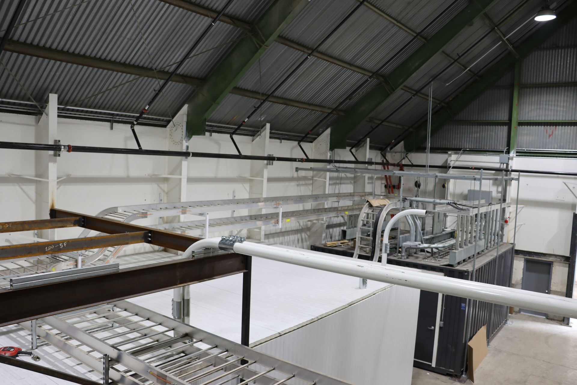 a large warehouse with a lot of pipes hanging from the ceiling .