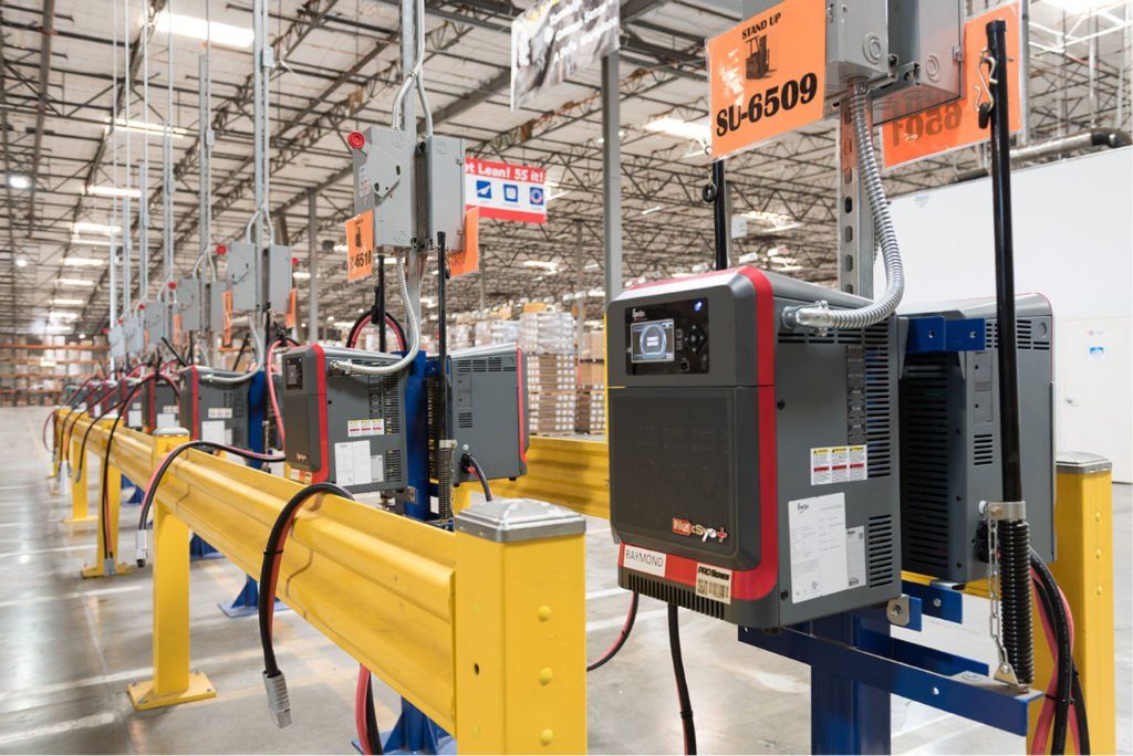 A row of chargers are lined up in a warehouse.