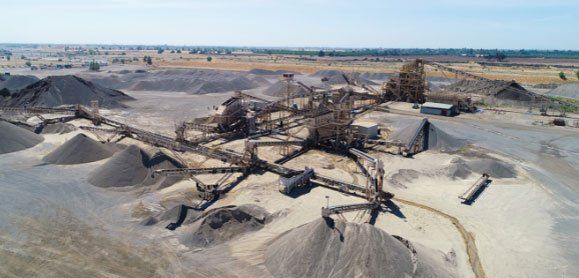 An aerial view of a sand quarry with a lot of piles of sand.