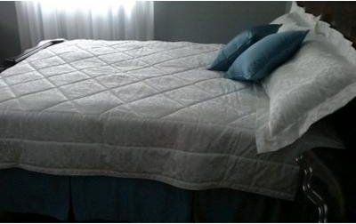 letto matrimoniale con trapunta e cuscini