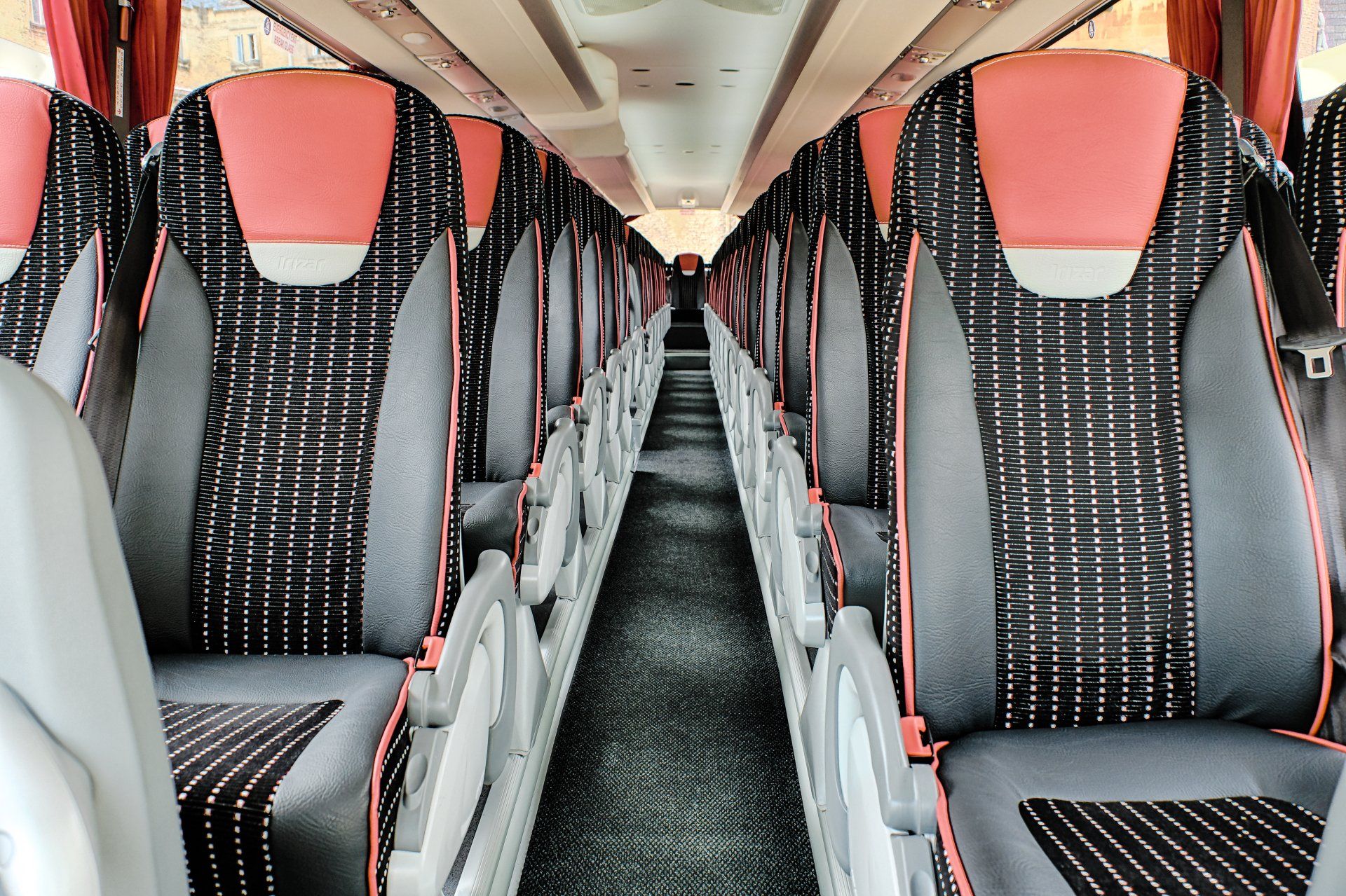 The inside of a bus with red and black seats