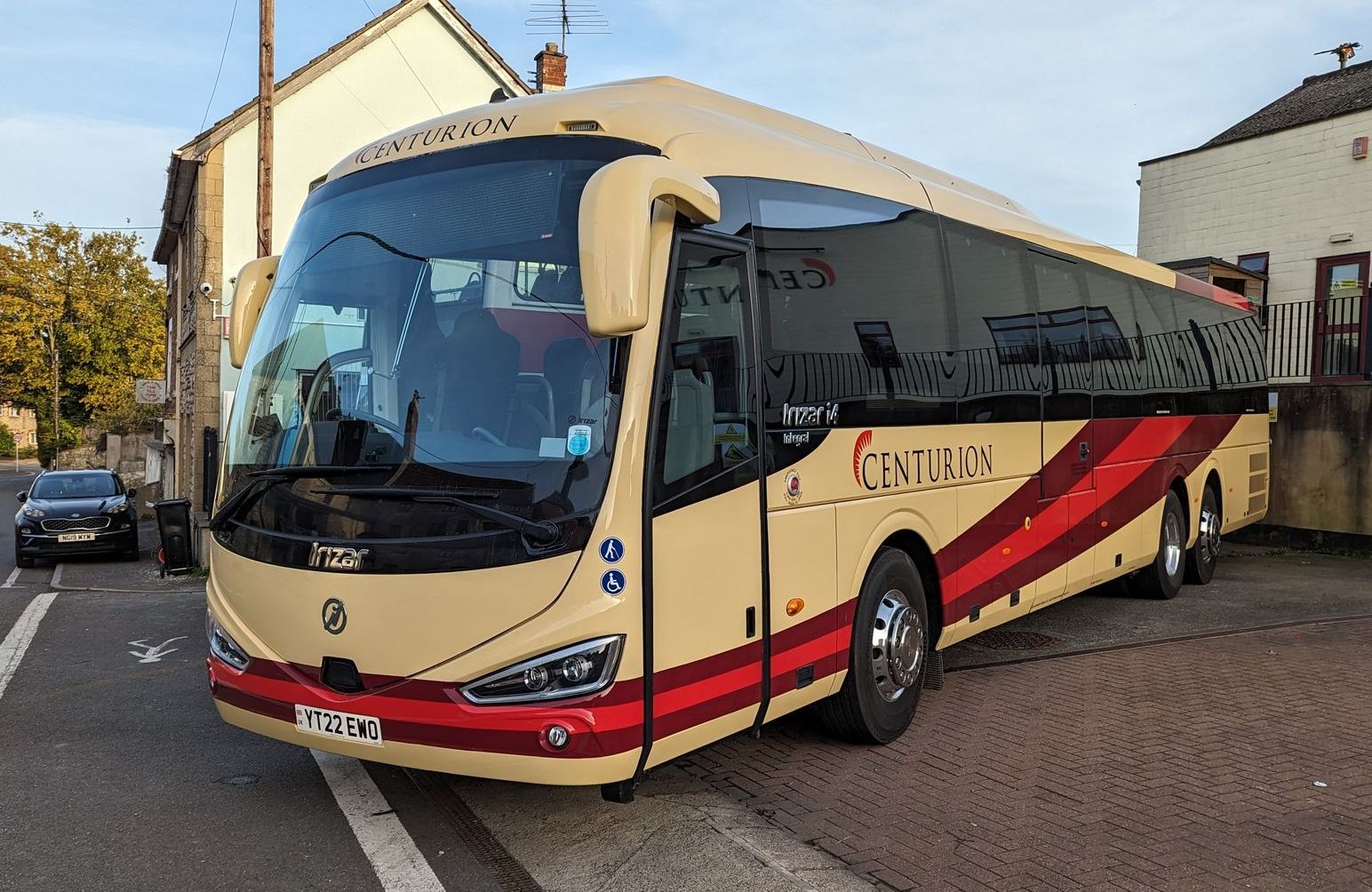 A large bus is parked on the side of the road in front of a building.