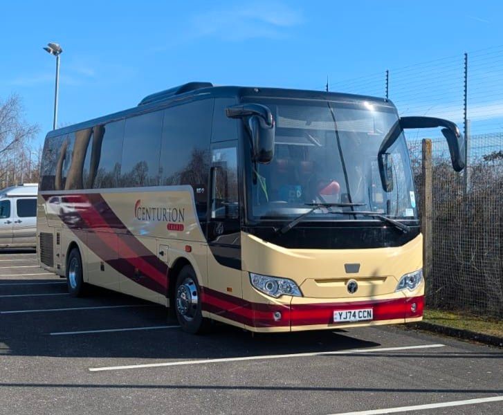 A large bus is parked in a parking lot.