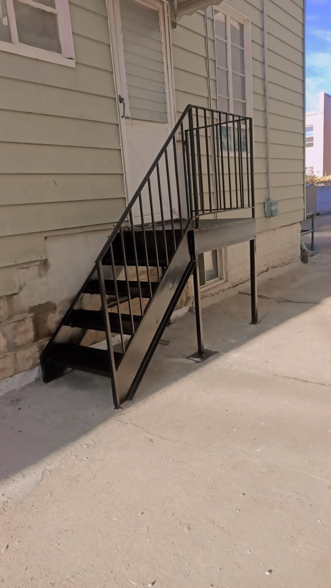 A set of stairs leading up to a house with a railing.