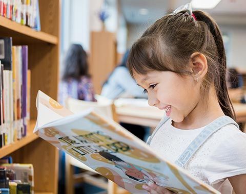Happy Little Girl Reading a Book | Fredericksburg, VA | Monroe Tutoring Center