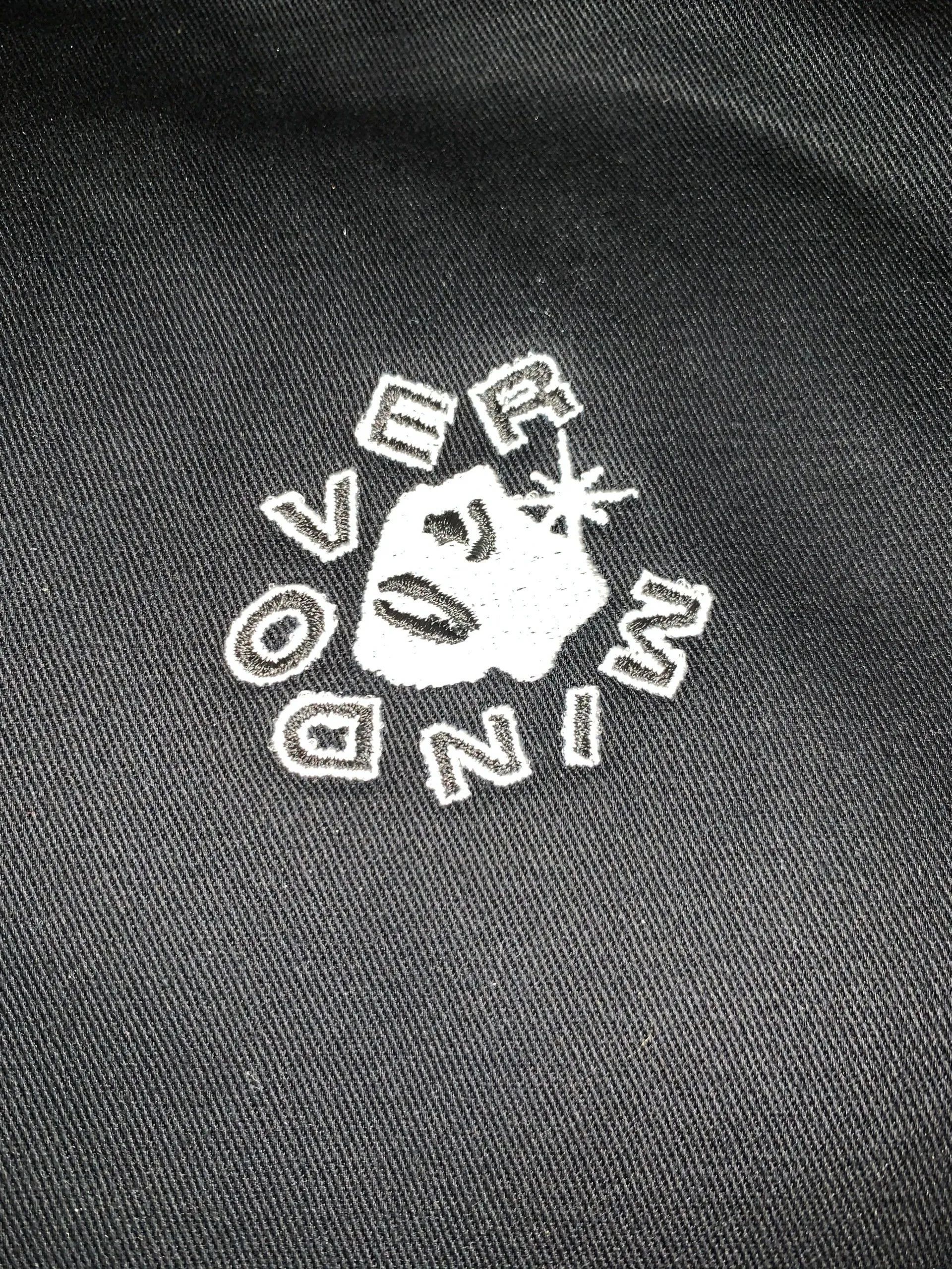 A close up of a black shirt with a white logo on it.