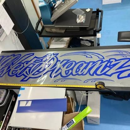 A sign with blue artwork on it — Cairns Custom T-Shirts In Cairns City, QLD