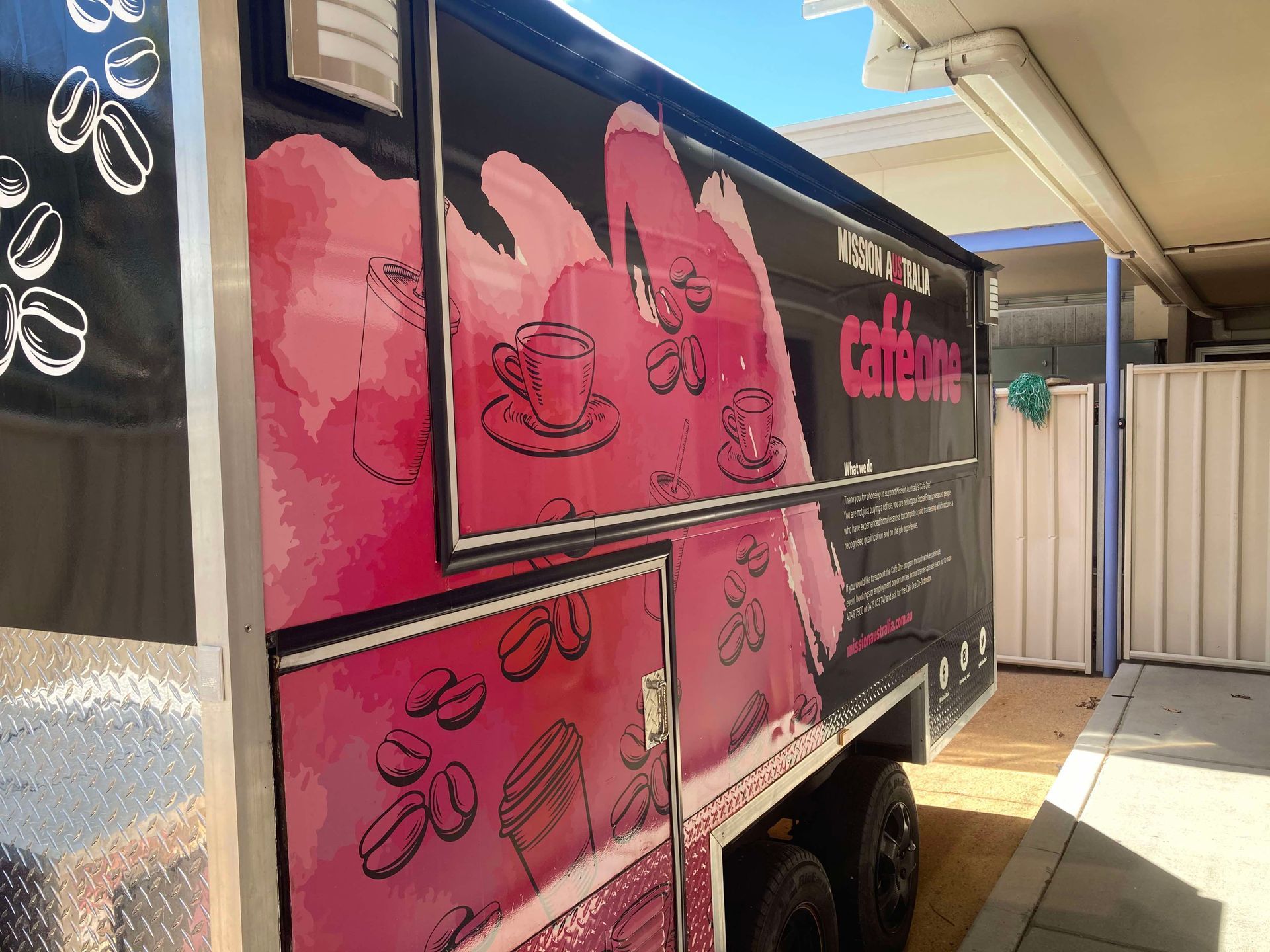 A pink and black food truck is parked in front of a building — Cairns Custom T-Shirts In Cairns City, QLD