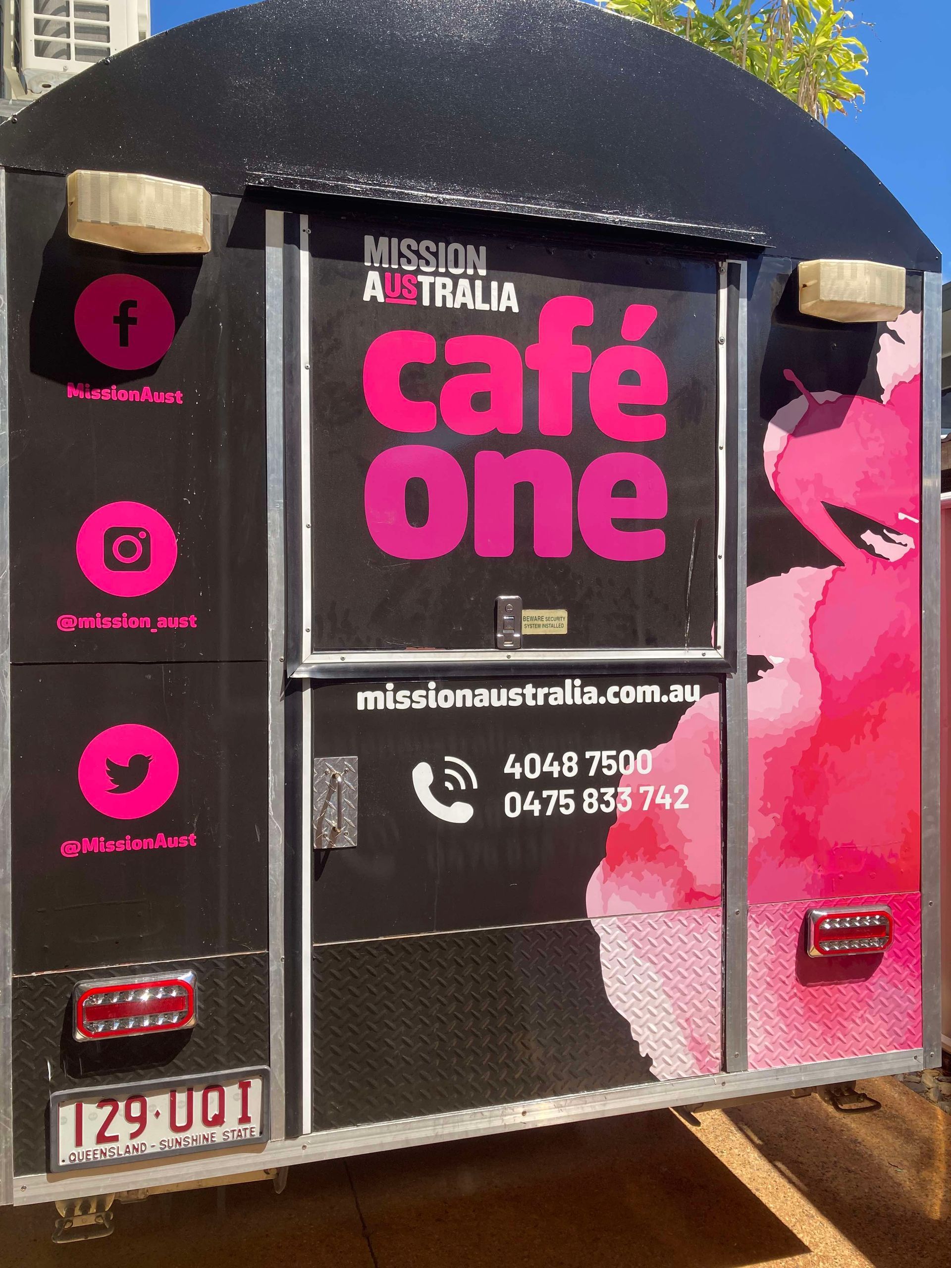 A black and pink cafe one trailer is parked in a parking lot — Cairns Custom T-Shirts In Cairns City, QLD