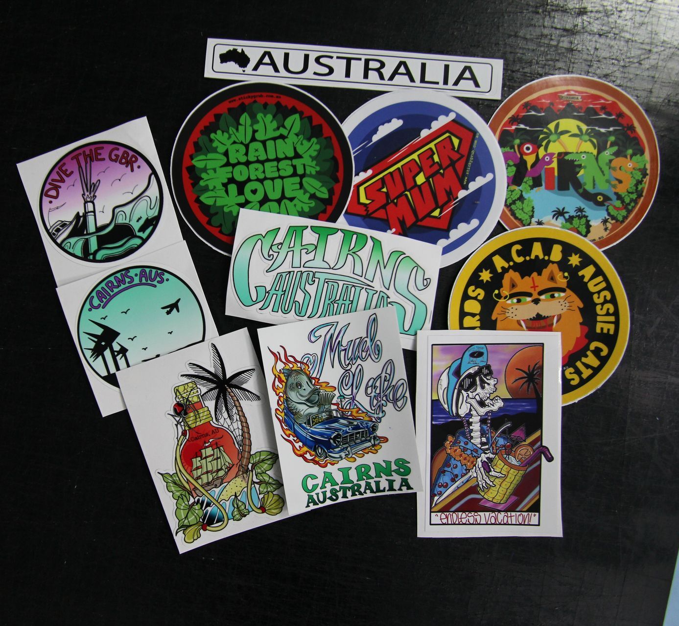 A Lot Of Stickers On A Black Table — Cairns Custom T-Shirts In Cairns City, QLD