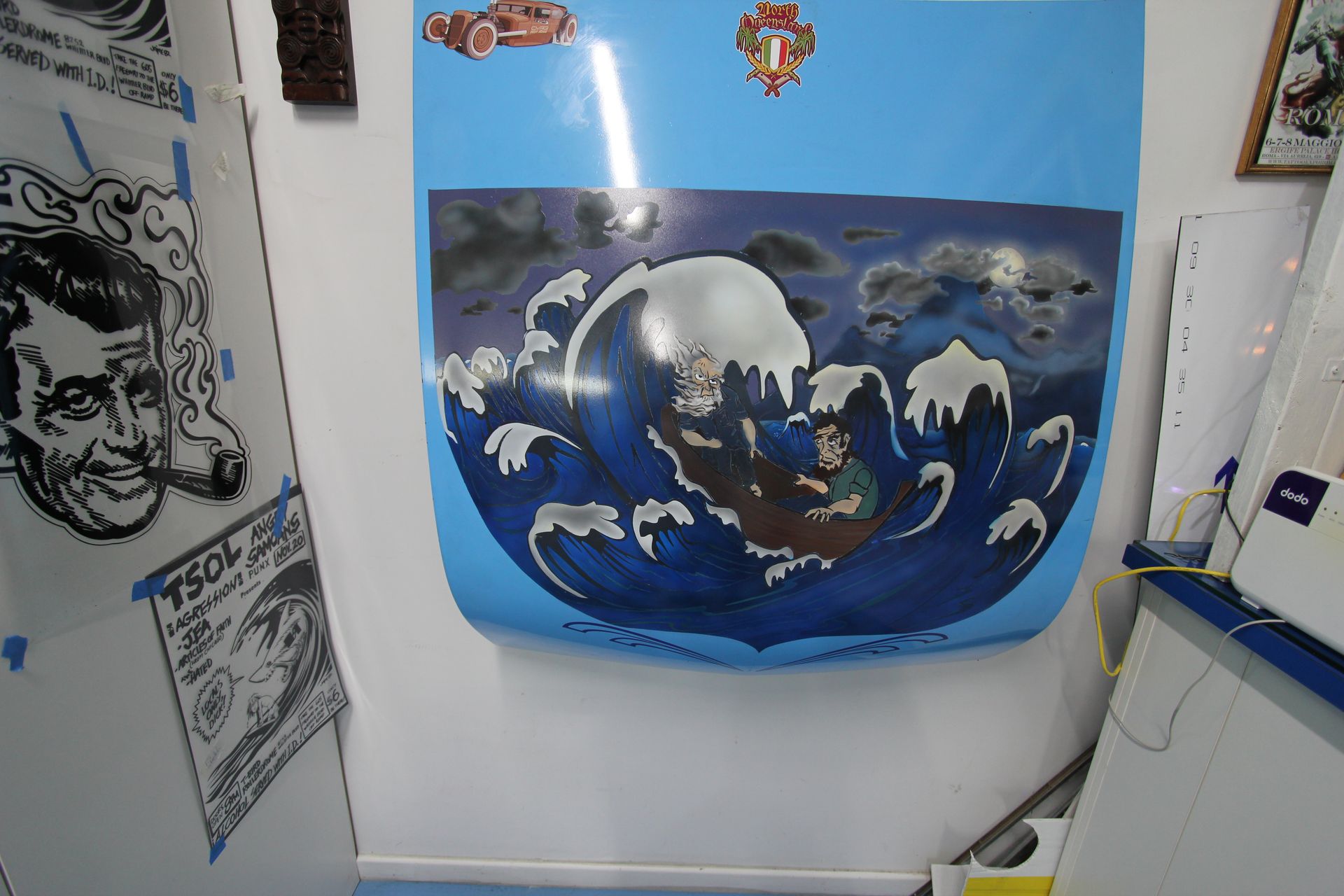 A painting of a man in a boat is hanging on a wall — Cairns Custom T-Shirts In Cairns City, QLD