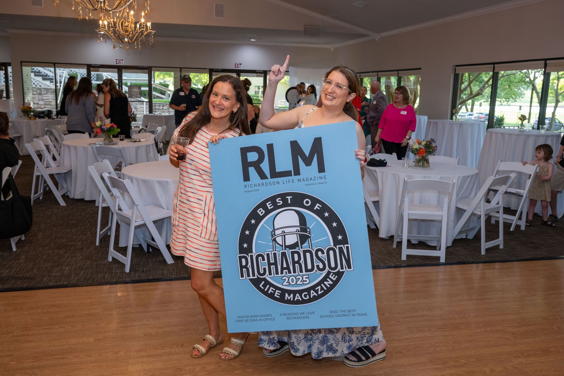 Two professionals sitting at a table outdoors, collaborating while looking at a laptop computer.