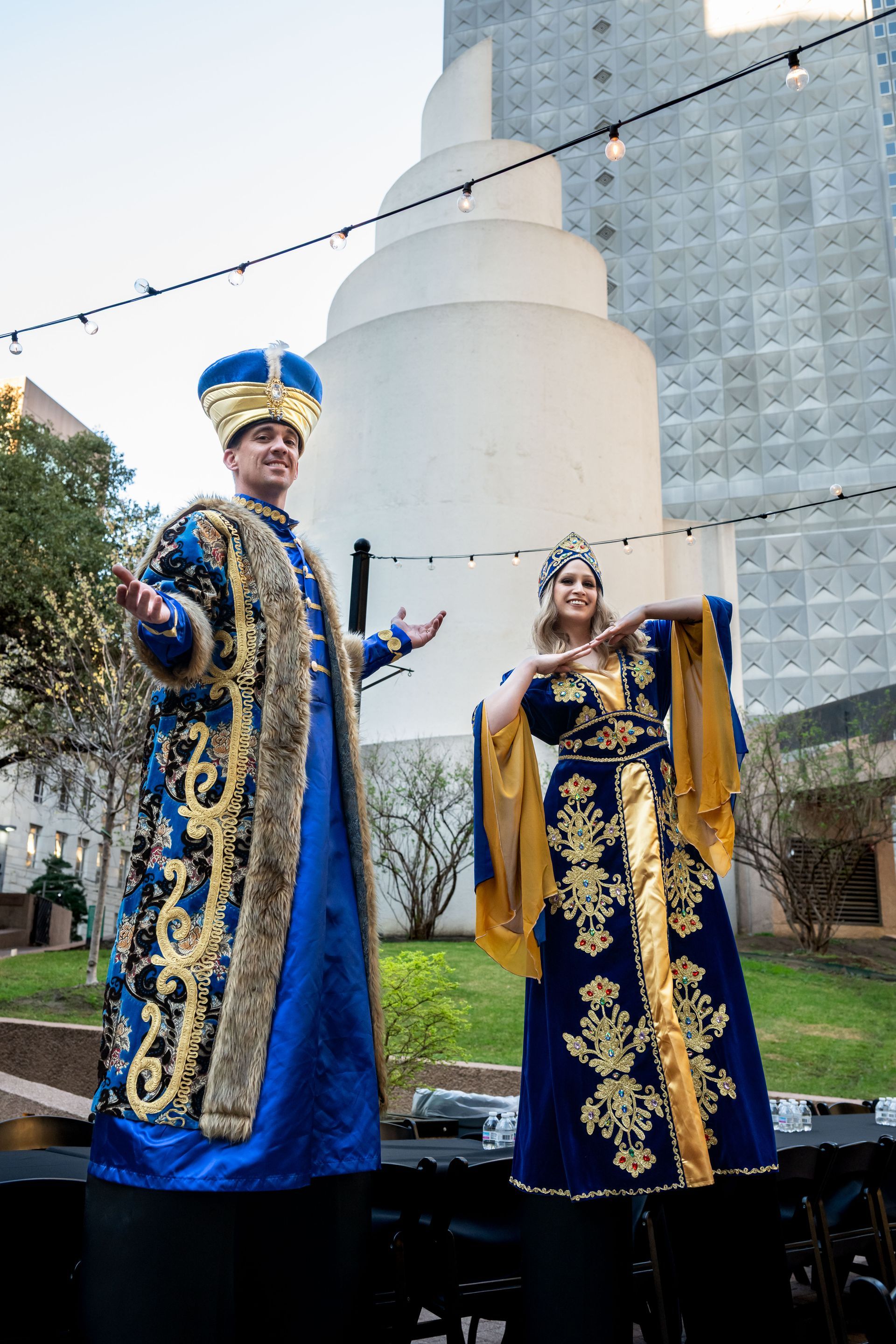 A woman in a beige blazer smiles while talking to a person in a dark suit at a professional networking event.