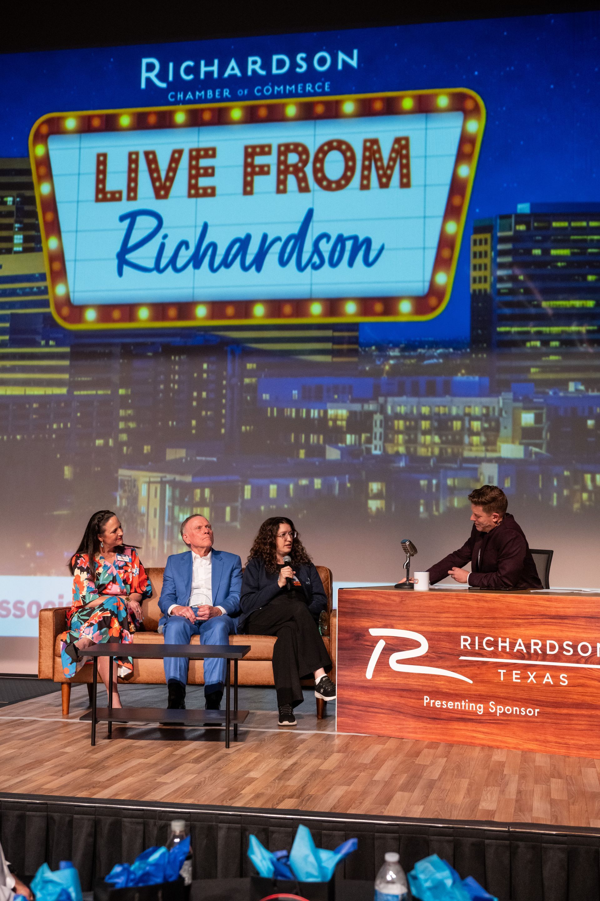 A panel discussion on a stage under a 