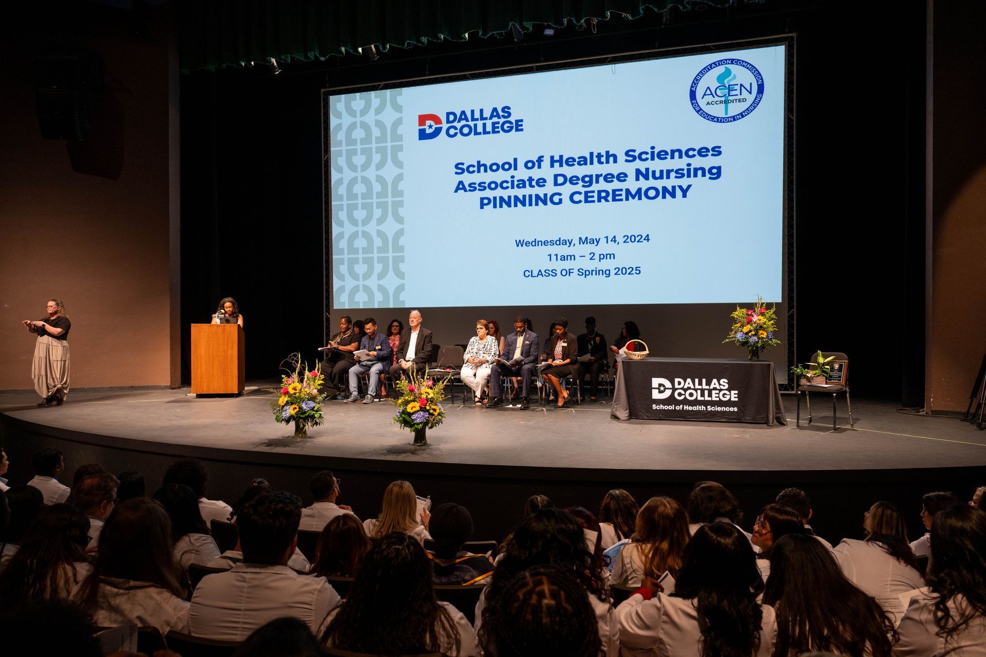 Dallas College School of Health Sciences Associate Degree Nursing Pinning Ceremony stage with speakers and audience.