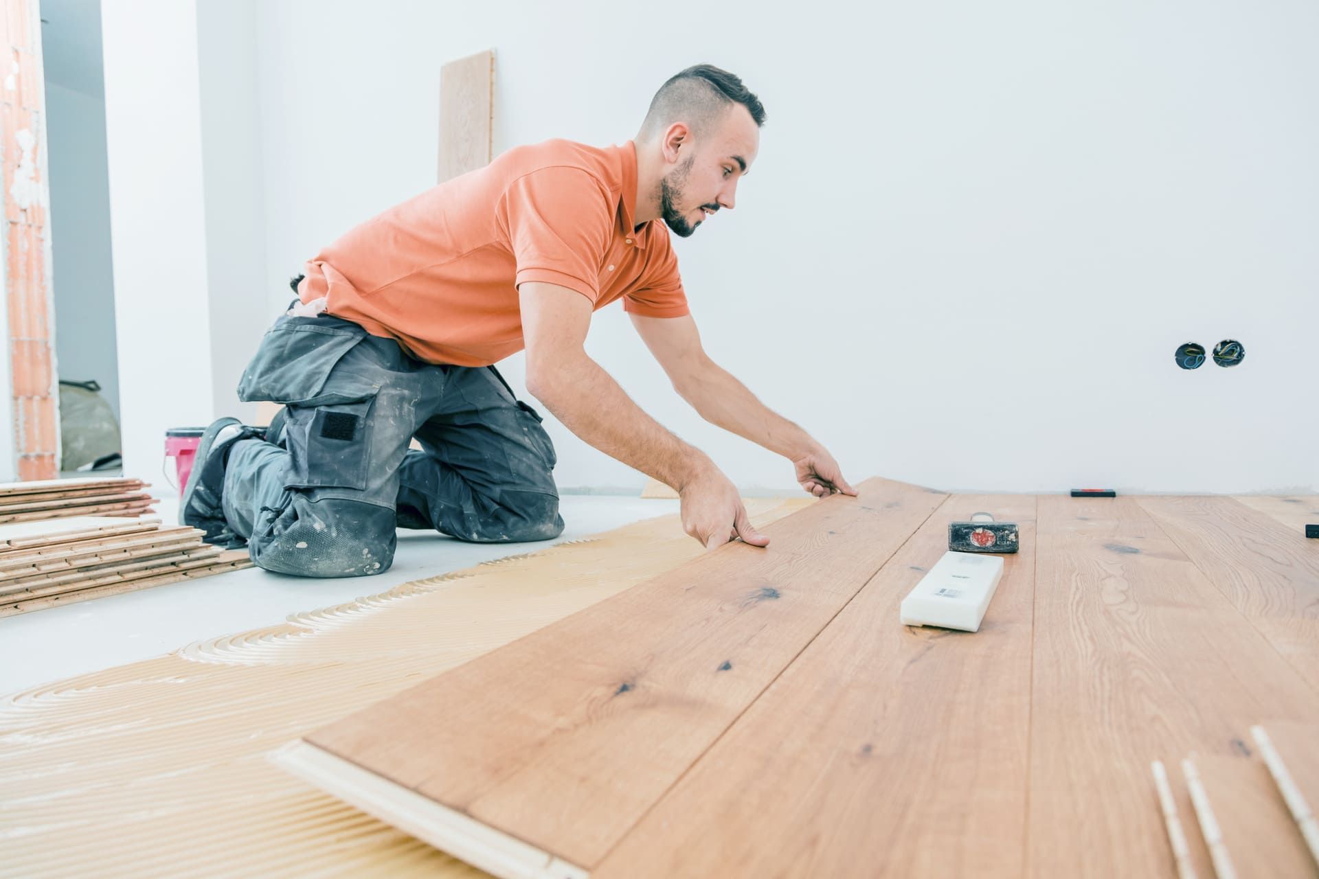 A Male Worker install wood floor on a house